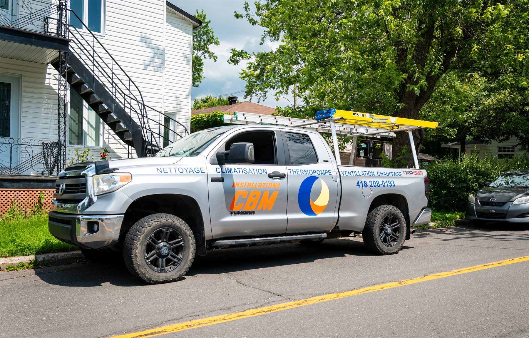 Camion de service Installations CBM stationné devant une résidence
